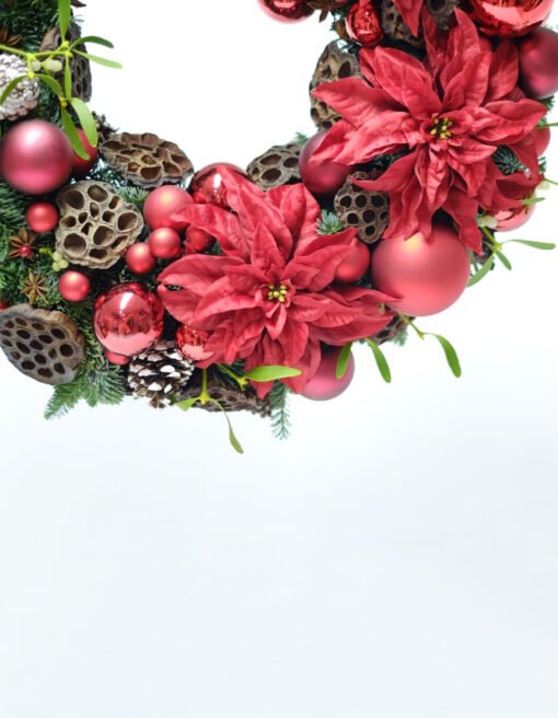 A wreath decorated with poinsettias close view