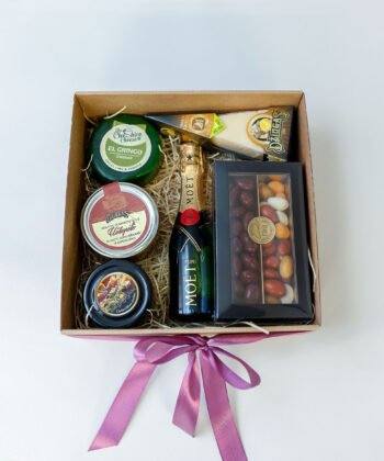 A box with various cheese, honey, sweets and champagne